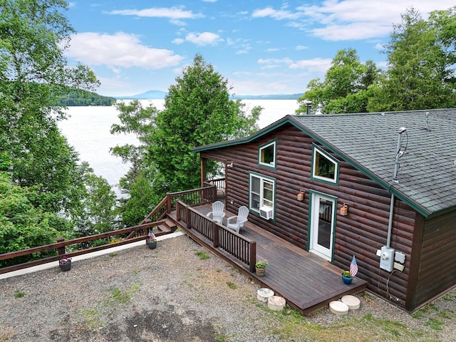 rear view of property featuring a deck with water view