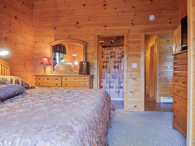 bedroom featuring dark carpet, baseboard heating, and wooden walls