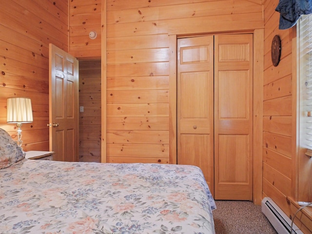 carpeted bedroom featuring a baseboard radiator, a closet, and wooden walls