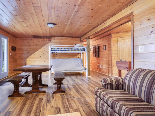 dining area featuring wood-type flooring, wood ceiling, and wooden walls