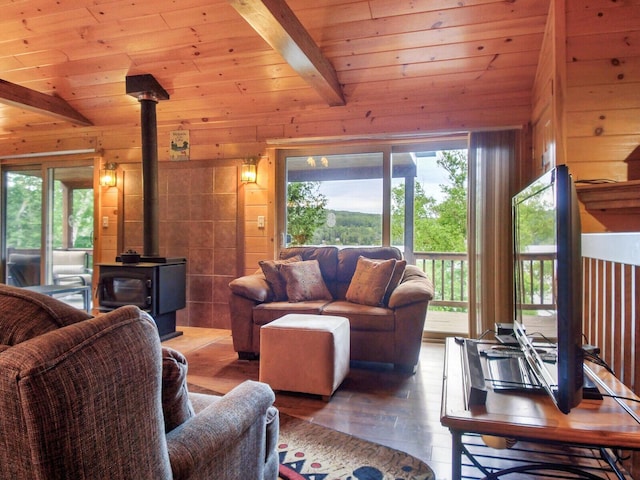 living room with a wood stove, vaulted ceiling with beams, wooden ceiling, and hardwood / wood-style flooring