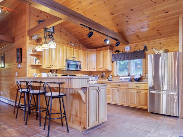 kitchen with light brown cabinets, track lighting, hanging light fixtures, vaulted ceiling with beams, and appliances with stainless steel finishes