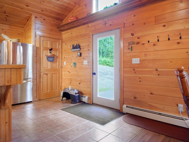 doorway to outside featuring baseboard heating, wood walls, light tile patterned flooring, and wood ceiling