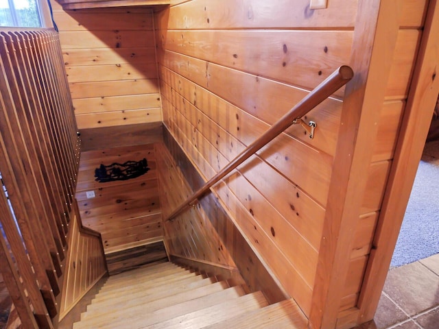 stairway with wooden walls and carpet floors