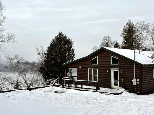 snow covered property with a deck