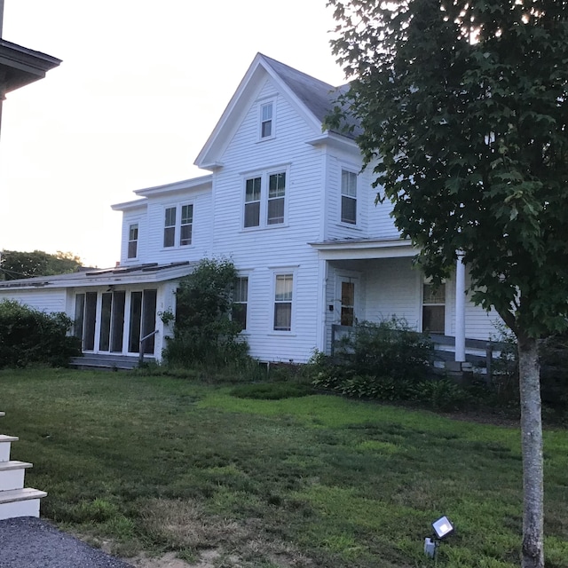 exterior space featuring a sunroom and a lawn