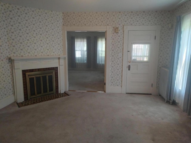 unfurnished living room featuring light colored carpet and a fireplace