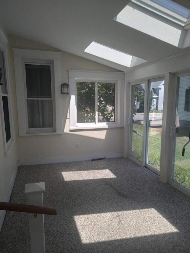 unfurnished sunroom with vaulted ceiling with skylight