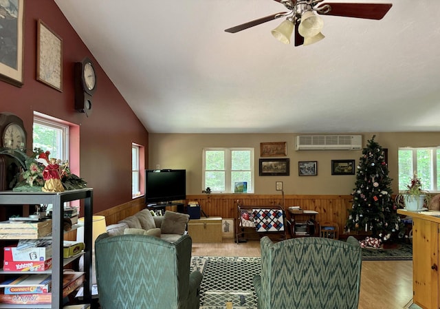 382 Water St, Guilford, ME 04443 - living area with a wall unit AC, a wainscoted wall, wooden walls, wood finished floors, and ceiling fan