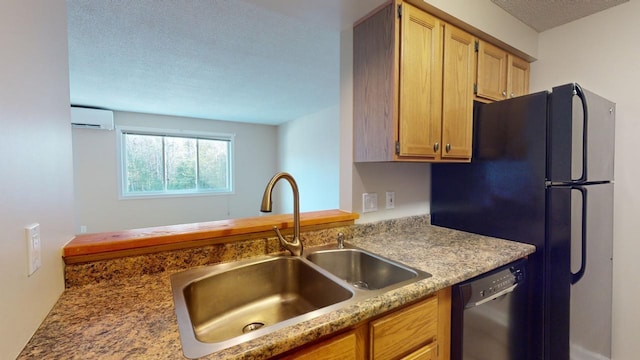 kitchen featuring black refrigerator, a textured ceiling, a wall unit AC, sink, and dishwasher