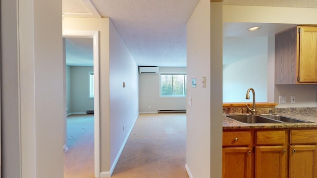 kitchen with a wall mounted air conditioner, sink, light carpet, and a baseboard radiator