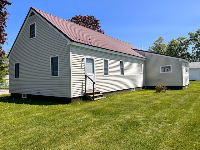 rear view of property featuring a lawn