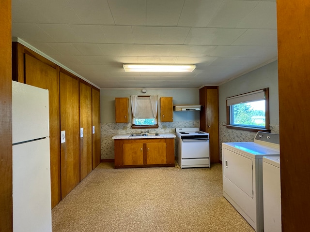 kitchen with white appliances, sink, light carpet, and washer and dryer