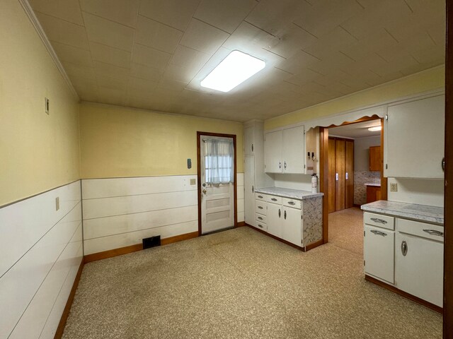 kitchen featuring white cabinets and light carpet