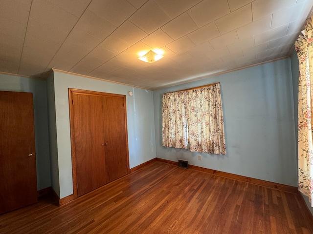 unfurnished bedroom with wood-type flooring and a closet