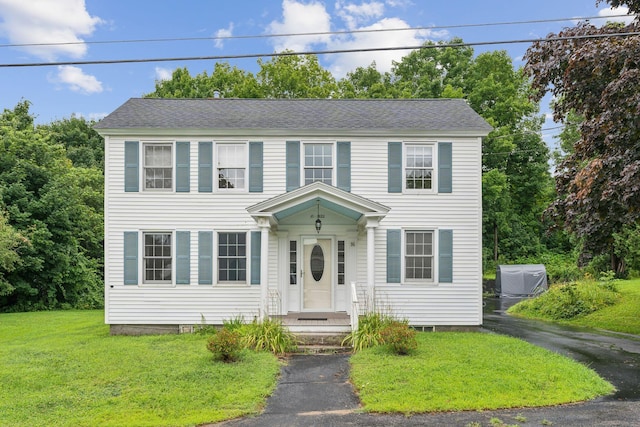 colonial inspired home featuring a front lawn