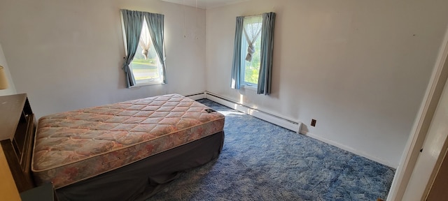 bedroom featuring baseboard heating, multiple windows, and carpet flooring