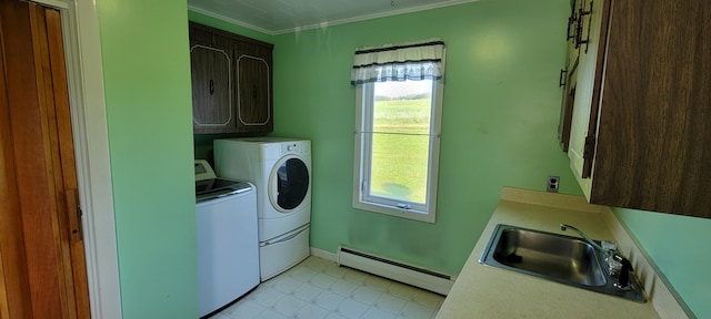 laundry area featuring a baseboard radiator, independent washer and dryer, cabinets, crown molding, and sink