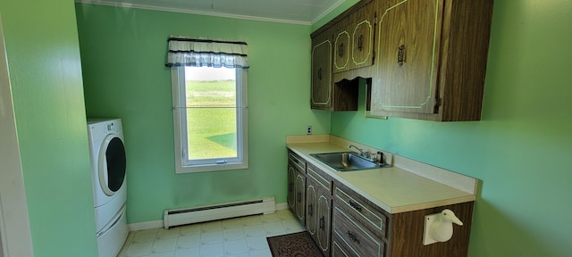 laundry area featuring washer / dryer, baseboard heating, cabinets, crown molding, and sink