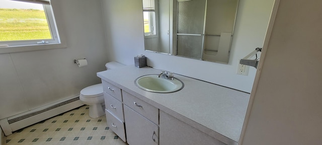 bathroom with toilet, vanity, and a baseboard heating unit