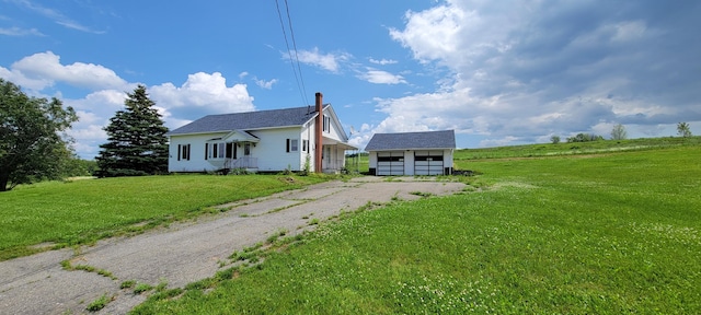 view of front of home with an outbuilding, a garage, and a front yard