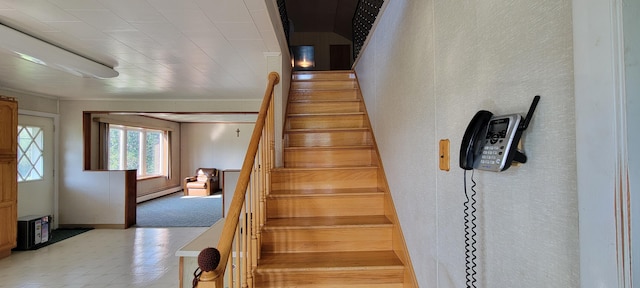 staircase featuring a baseboard heating unit