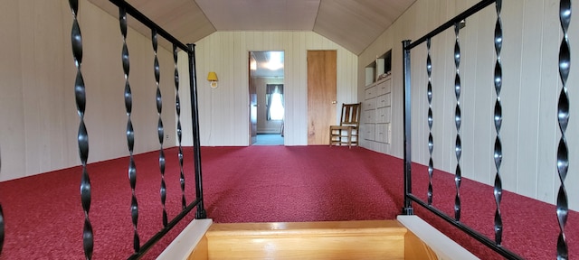 interior space with baseboard heating, lofted ceiling, and wooden walls