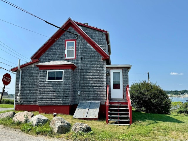 rear view of property featuring a lawn