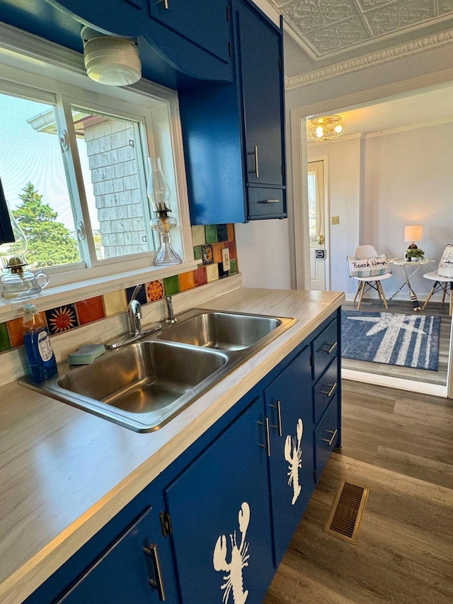 kitchen featuring blue cabinets, dark hardwood / wood-style floors, and sink