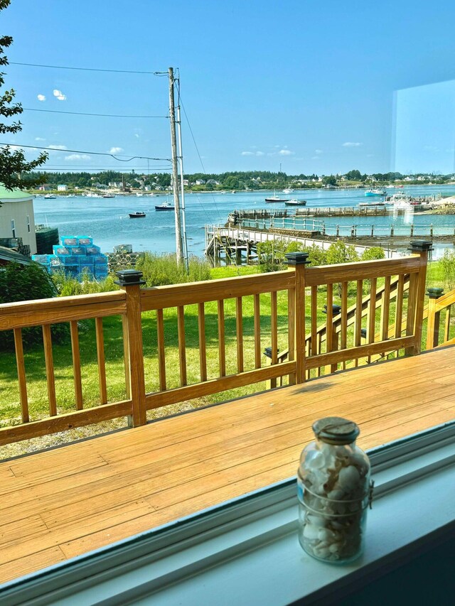 wooden terrace featuring a yard and a water view