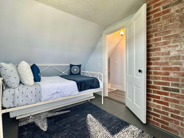 bedroom featuring lofted ceiling and a textured ceiling