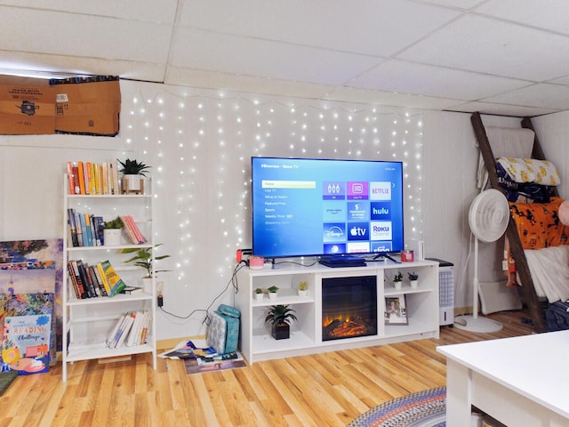 living room with wood-type flooring and a drop ceiling