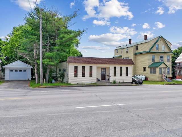 view of front of home featuring a garage and an outbuilding