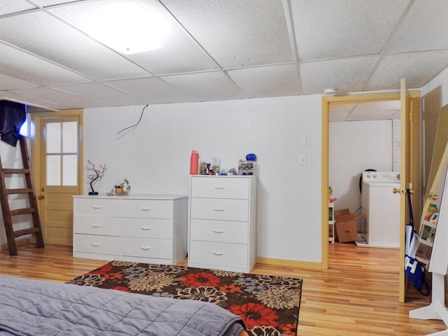 bedroom with washer / clothes dryer, a paneled ceiling, and light hardwood / wood-style floors