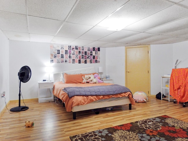 bedroom with a paneled ceiling and wood-type flooring