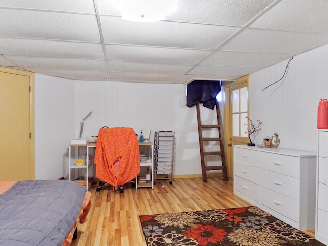 bedroom with a paneled ceiling and light hardwood / wood-style floors