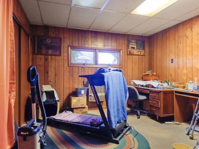 carpeted office with a paneled ceiling and wooden walls