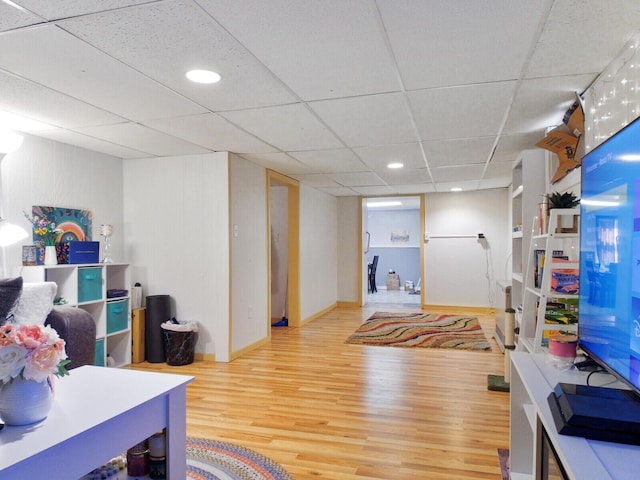 game room with a paneled ceiling and hardwood / wood-style flooring