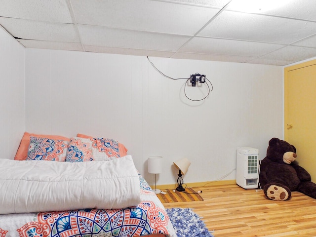 bedroom with hardwood / wood-style flooring and a paneled ceiling