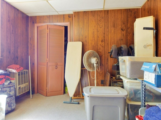 miscellaneous room featuring a paneled ceiling and wood walls