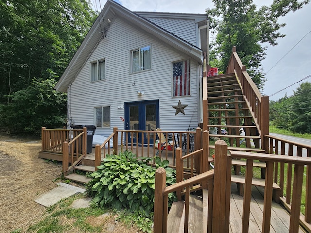 rear view of house with french doors and a wooden deck