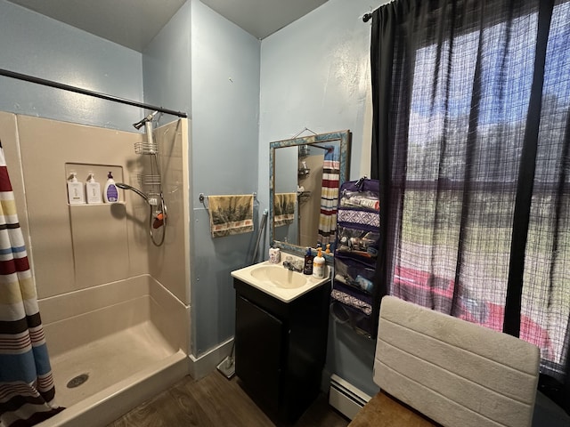 19 River Rd, Oakfield, ME 04763 - full bathroom with a stall shower, a baseboard radiator, vanity, and wood finished floors