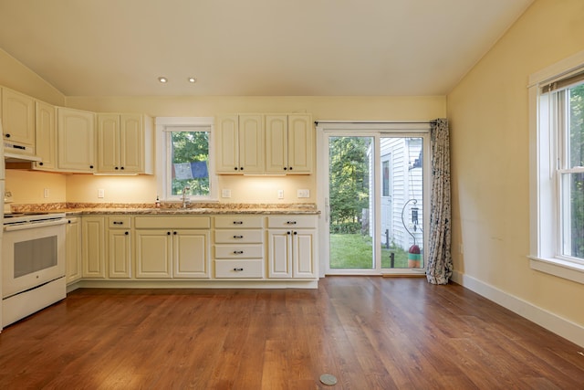 kitchen with light stone countertops, white electric stove, sink, dark hardwood / wood-style floors, and vaulted ceiling