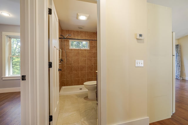 bathroom with toilet and a tile shower