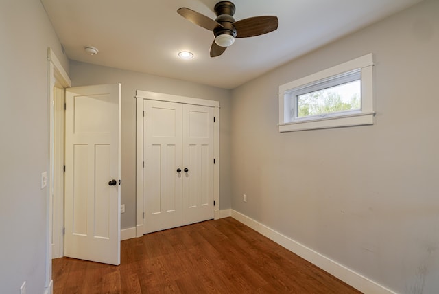 unfurnished bedroom featuring ceiling fan, a closet, and wood-type flooring