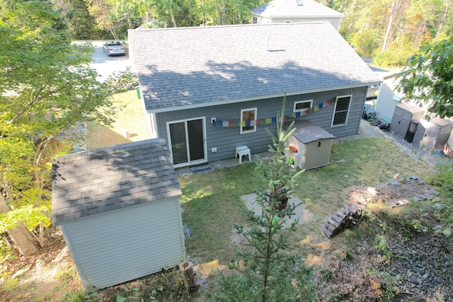 back of house featuring a storage unit and a yard