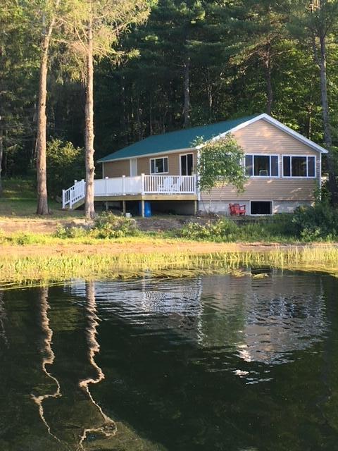 rear view of house with a view of trees and a water view