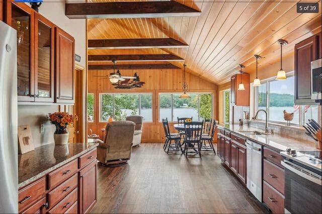 kitchen featuring lofted ceiling with beams, plenty of natural light, a sink, and dark wood-type flooring