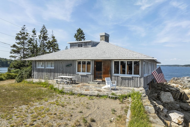 back of house featuring a patio and a water view