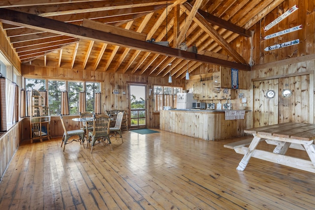 interior space with wood-type flooring, high vaulted ceiling, and wood walls